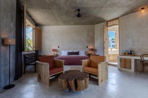 a bedroom with a bed and a table and chairs at El Mambo Boutique Hotel in Las Terrenas