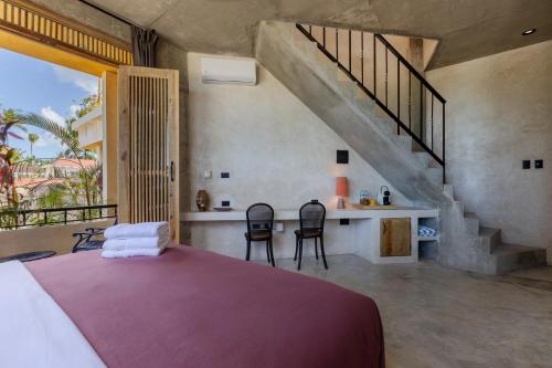 a bedroom with a large bed and a staircase at El Mambo Boutique Hotel in Las Terrenas
