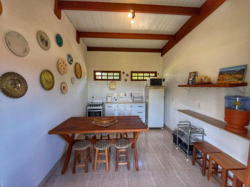 a kitchen with a wooden table and some chairs at Sons da Canastra Pousada e Terapias - em São José do Barreiro - São Roque de Minas MG in São Roque de Minas
