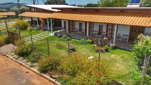 a house with a garden in front of it at Sons da Canastra Pousada e Terapias - em São José do Barreiro - São Roque de Minas MG in São Roque de Minas
