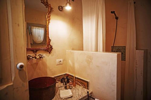 a bathroom with a sink and a mirror at Villa Li Curti con piscina in comune, un'oasi in paese! in Ortelle