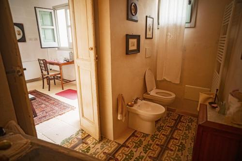 a bathroom with a toilet and a sink at Villa Li Curti con piscina in comune, un'oasi in paese! in Ortelle
