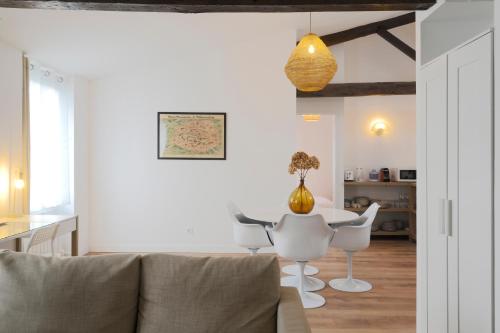 un salon avec une table et des chaises blanches dans l'établissement T3 cosy aux portes de Paris, à Saint-Denis