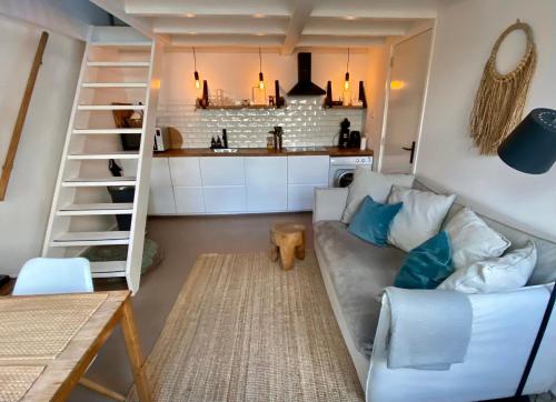a living room with a couch and a kitchen at Zilt Noordwijk in Noordwijk aan Zee