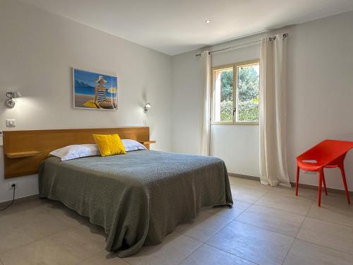 a bedroom with a bed and a red chair at Domaine Villas Celia in Monticello