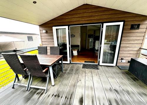 a wooden deck with a table and chairs on it at Beach Chalet- Sauna inklusive Kinder und Hunde Willkommen in Scharbeutz