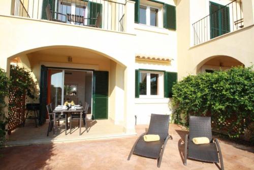 a patio with chairs and a table in front of a building at Residence Club el Paraiso 30 in Sa Ràpita
