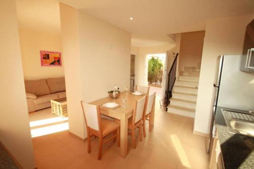 a dining room with a table and chairs and a couch at Residence Club el Paraiso 30 in Sa Ràpita