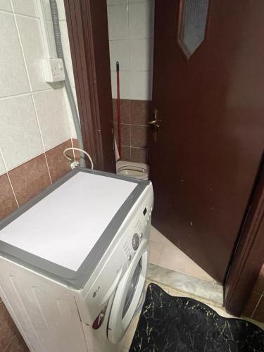 una lavatrice in un bagno con una porta di Kelly homes a Abu Dhabi