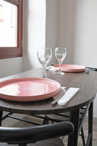 - une table avec deux assiettes et des verres à vin dans l'établissement Gîte climatisé 