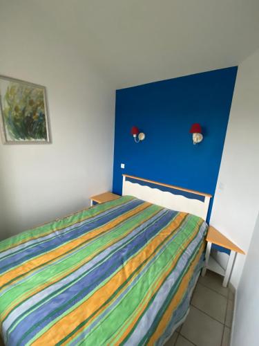 une chambre avec un lit avec une tête de lit bleue dans l'établissement Appt 5 personnes dans une résidence Pierre&vacances, à Talmont-Saint-Hilaire
