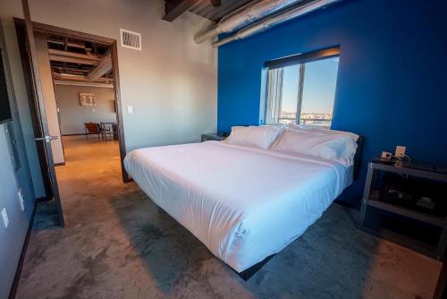 a bedroom with a large bed with a blue wall at Brewhalla Hotel in Fargo