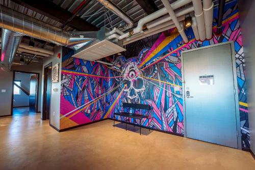 a colorful mural on a wall in a room at Brewhalla Hotel in Fargo