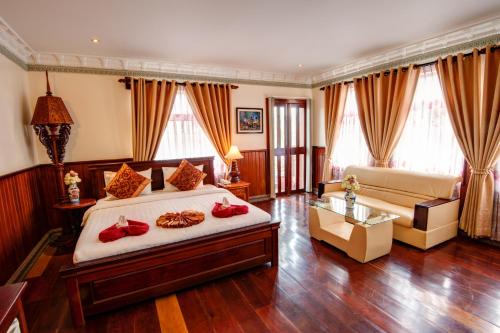 a large bedroom with a bed and a couch at Okay Boutique Hotel in Phnom Penh