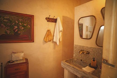 a bathroom with a sink and a mirror at Suites Li Curti, camere con piscina! in Ortelle
