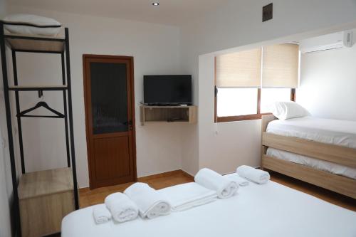 a hotel room with two beds and a television at Guest House ESANBJA in Berat