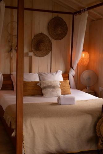 a bedroom with a bed with white sheets and pillows at Whaka Lodge in Seissan