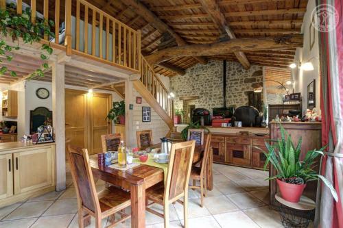 une cuisine avec une table et des chaises en bois dans l'établissement Le clos du martouret, à Roisey