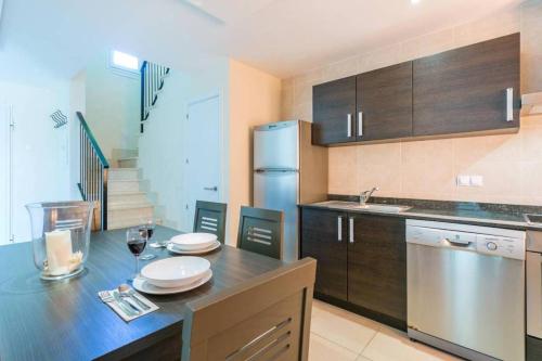 a kitchen with a table with plates and wine glasses at Residence Club el Paraiso 37 in Sa Ràpita