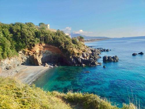 a beach with a house on top of a cliff at EC apartment in Scalea