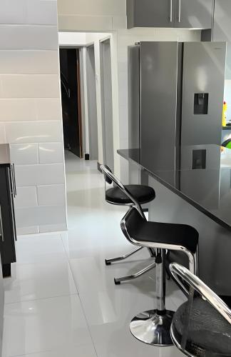 a kitchen with a black counter and two stools at Alexandrina's Corner in Chipata