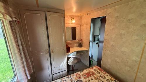a small bedroom with a sink and a mirror at Bungalow modulo con jardin in El Bosque