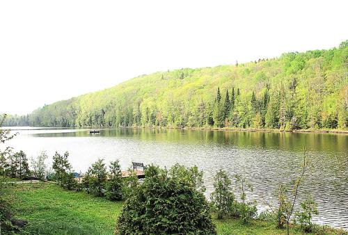 een bank aan de rand van een meer bij Chalet du lac long in Saint Come