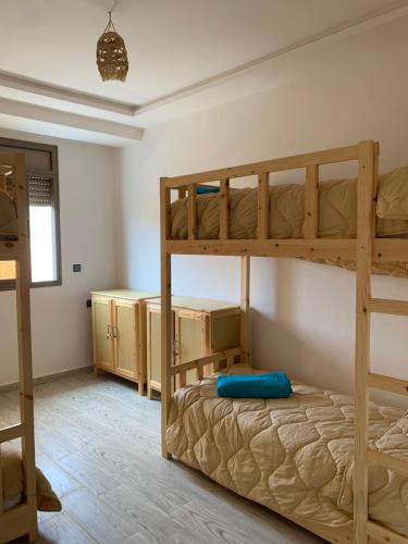 a bedroom with two bunk beds in a room at Nomad Surf Lodge in Imsouane