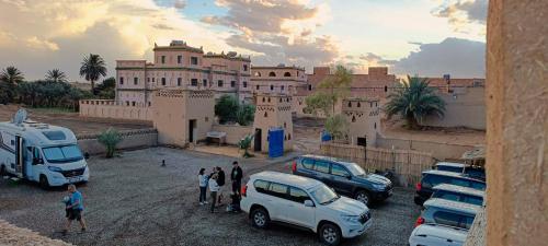 a group of people standing in a parking lot in front of a building at Hotel Les Roches Merzouga in Merzouga