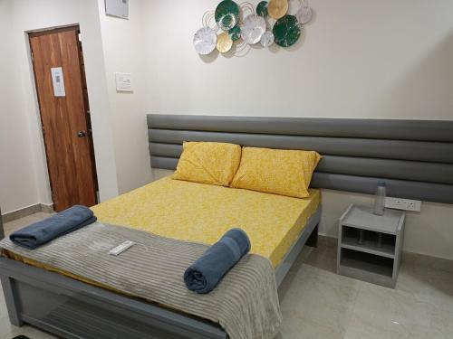 LingampalliにあるYendluri's - Studio Flat-3 Kondapur, Gachibowliのベッド(黄色のシーツ、枕付)