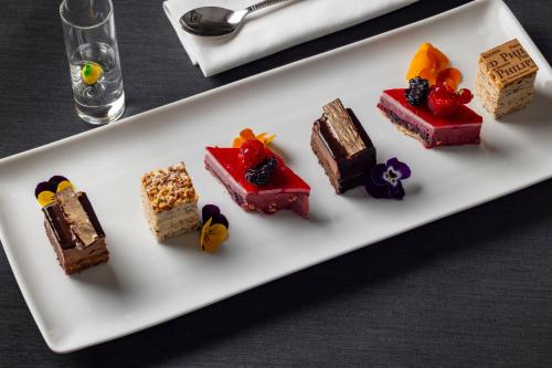 a white plate with different types of desserts on it at La Bastide de Damien, 5 clefs Demeure d'Exception et Table Remarquable dans le guide Teritoria, JACUZZI Privatif, Cuisine étoilée Dominique Frérard in Aix-en-Provence