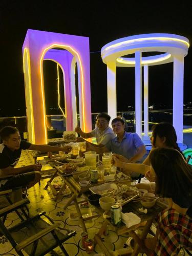 a group of people sitting around a table at night at Coco Bay Hon Son in Lai Sơn
