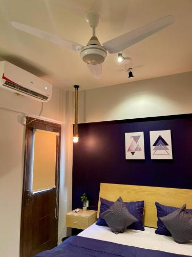 a bedroom with purple walls and a bed with purple pillows at Beachfront Studios by Virani in Karachi