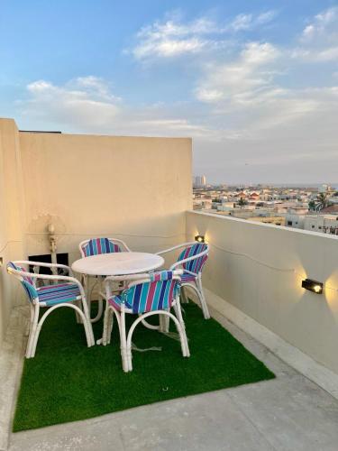 a table and chairs on a balcony with a view at Beachfront Studios by Virani in Karachi