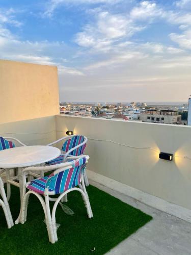 a table and chairs on a balcony with a view at Beachfront Studios by Virani in Karachi