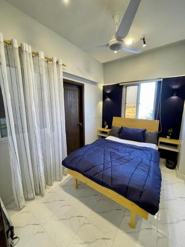 a bedroom with a bed with a blue comforter at Beachfront Studios by Virani in Karachi