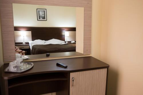 a hotel room with a bed and a mirror at Hotel Rina Cerbul in Sinaia