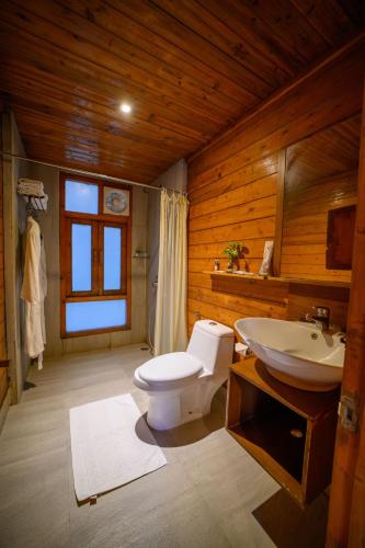 a bathroom with a toilet and a sink at Sinclairs Retreat Dooars, Chalsa in Chālsa