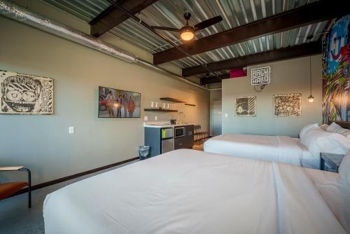 a bedroom with two beds and a kitchen at Brewhalla Hotel in Fargo