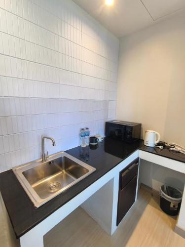 a kitchen with a sink and a microwave at Lek Lek Samui Room X Coffee Bar in Chaweng