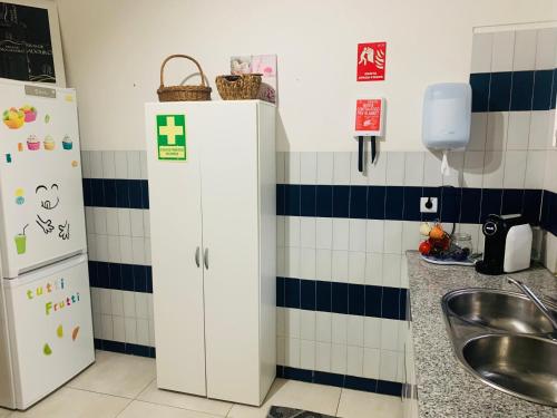 a kitchen with a refrigerator and a sink at Anjú-Pardal in Mogadouro