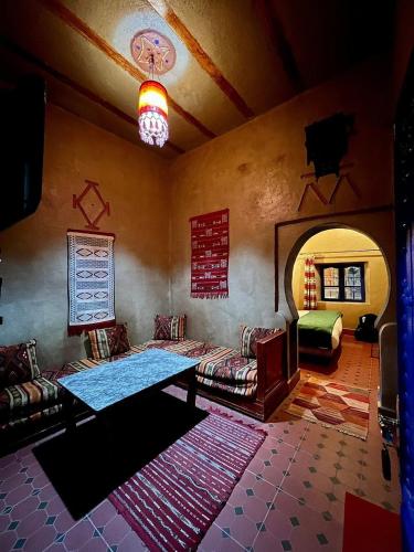 a living room with a couch and a table in it at Hotel Les Roches Merzouga in Merzouga