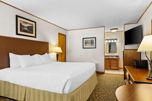 a large white bed in a hotel room at Best Western Adirondack Inn in Lake Placid