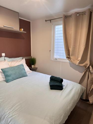 une chambre avec un grand lit blanc avec une fenêtre dans l'établissement Camping la jasse sables du midi 4 étoiles, à Valras-Plage