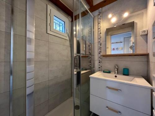une salle de bain avec une douche, un lavabo et un miroir dans l'établissement Mais 3 pièces 4 couchages SAINT GEORGES D'OLERON SGO000-074, à Saint-Georges-dʼOléron
