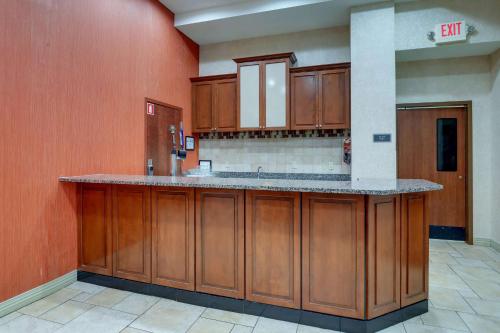 a large kitchen with wooden cabinets and a counter at Drury Inn & Suites Charlotte Northlake in Charlotte