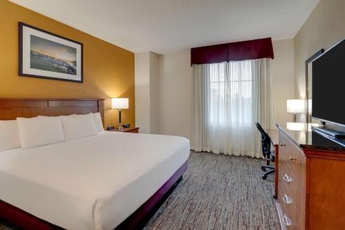 a hotel room with a bed and a flat screen tv at Drury Inn & Suites Charlotte Northlake in Charlotte