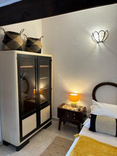 a bedroom with a bed and a table with a lamp at L'Aghjalle in Santa-Reparata-di-Balagna