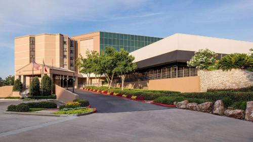 an office building with a road in front of it at Sonesta Hotel Houston IAH Airport in Houston