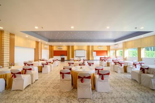 a banquet hall with white tables and red bows at Sinclairs Retreat Dooars, Chalsa in Chālsa